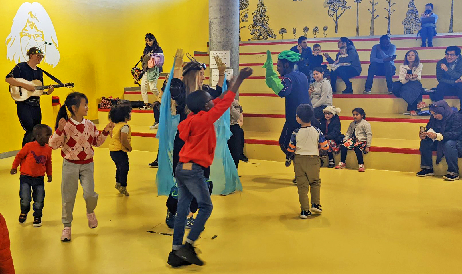 Three performers and lots of children move expressively